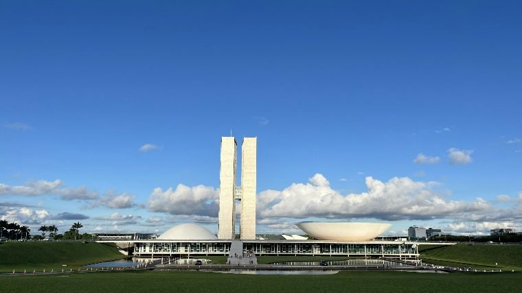 Congresso Nacional em Brasília sob céu azul, em dia de sol
