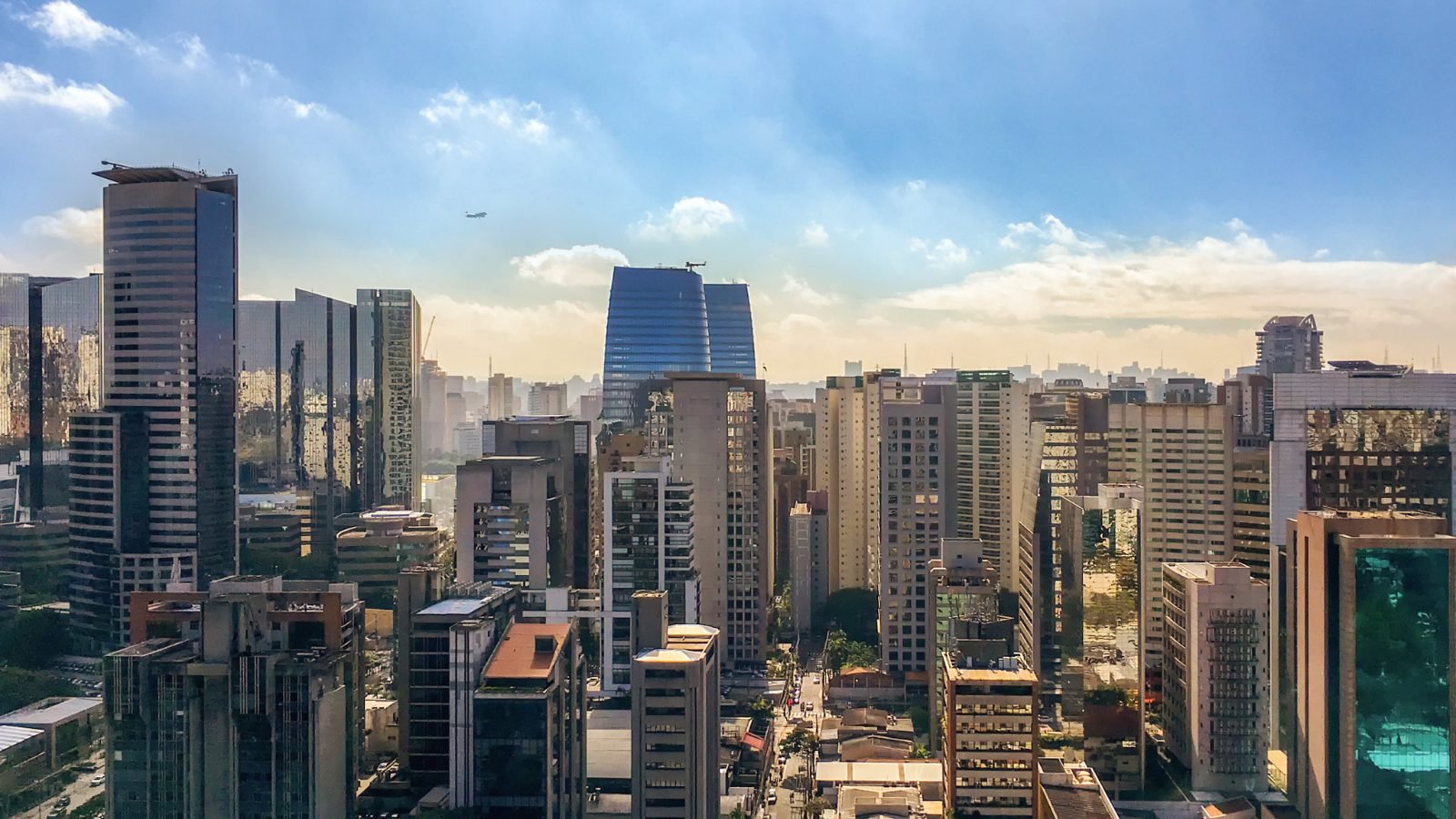 Prédios residenciais e comerciais do Itaim Bibi, em São Paulo, sob céu azul com nuvens